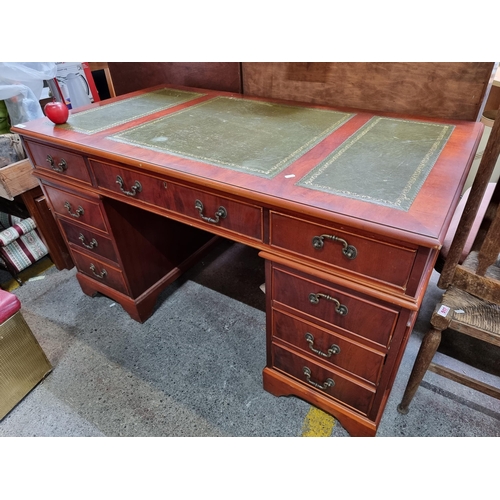 389 - Star Lot : A nine-drawer knee hole desk with tooled green leather inlay and guild detail (shamrock, ... 