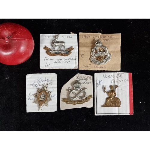 277 - A selection of five WWII military cap badges, including a Staffordshire knot, a Royal Warwickshire r... 