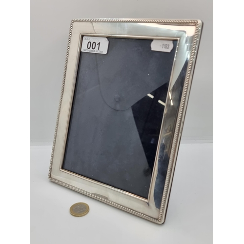 1 - A sterling silver photo frame, with wood back to reverso. Internal dimensions: 12.5cm x 17.5 cm.