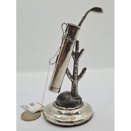 22 - An interesting Sterling silver item featuring a golf bag and club resting on a tree branch, with foo... 