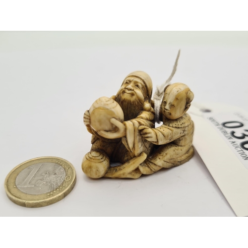 30 - An antique Japanese ivory hand carved Netsuke, depicting a old man and child companion.