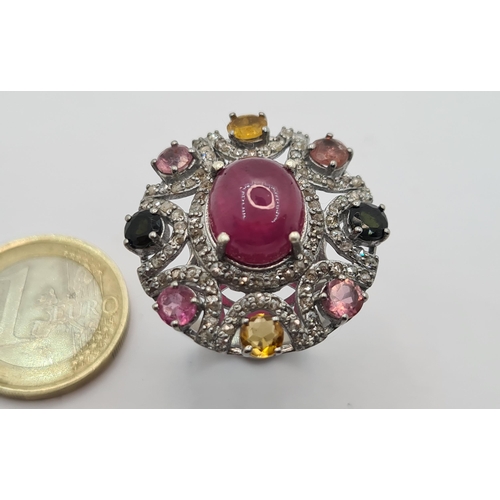 38 - An impressive ring with large cabochon ruby (7.35)  and ornate sterling silver surround set with pin... 
