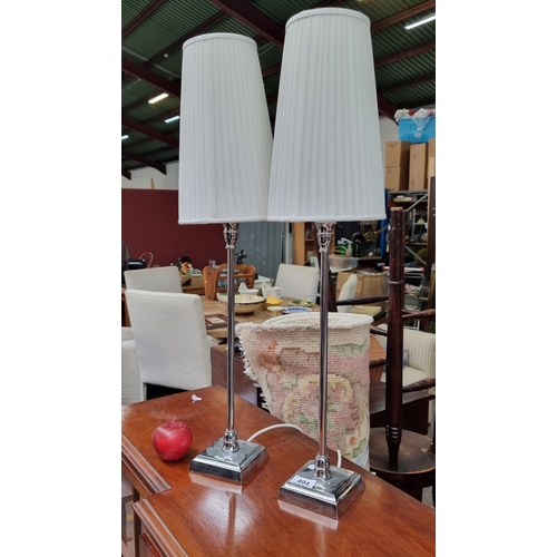 494 - Two sleek tall table lamps with chrome base and pleated cream shade.