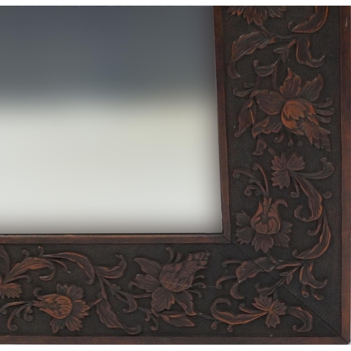 2039 - Large hard wood bevelled edged mirror carved with flowers and foliage, 166cm x 84cm