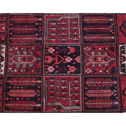 2035 - Rectangular Bakhtiari rug with an all over panelled design onto a red ground, 242cm x 156cm