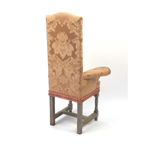 2058 - Bleached wooden framed child's correction chair with outswept arms and peach upholstery, 110cm high