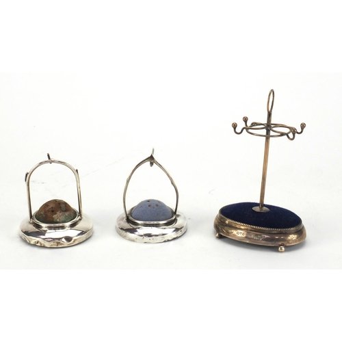 16 - Three silver hat pin and ring stands, various hallmarks, the largest 11cm high