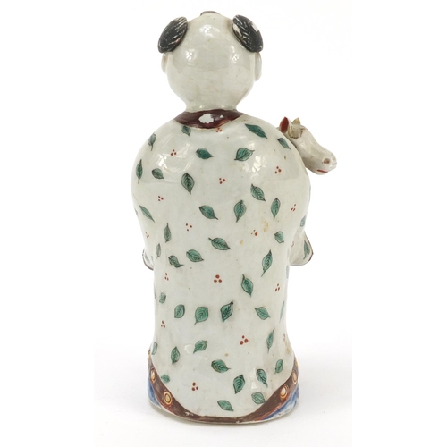 32 - Chinese porcelain figure of a boy holding a toy horse hand painted with leaves, 20.5cm high