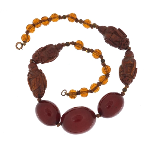 13 - Chinese cherry amber coloured bead and carved coquilla nut necklace, 40cm in length