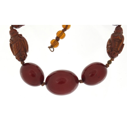 13 - Chinese cherry amber coloured bead and carved coquilla nut necklace, 40cm in length