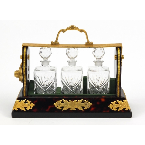 49 - Boulle work style three bottle tantalus with a gilt metal mount, 26.5cm wide