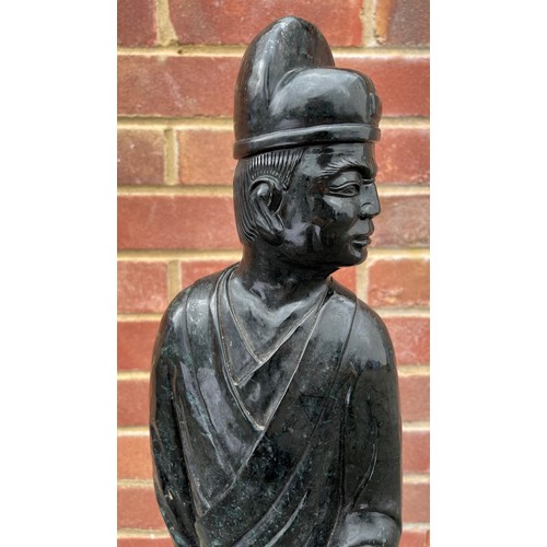 50 - Large Chinese carved green/black stone figure of a standing figure holding a scroll, 69cm high