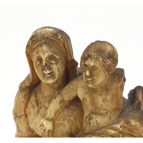14 - Antique ivory carving of Madonna and child raised on an ebonised and ivory base, 14cm high