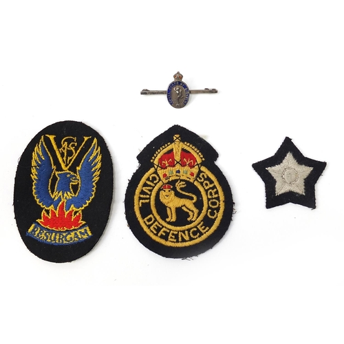 1442A - Militaria to include civil defence uniforms with black buttons, silver and enamel brooch and cloth p... 