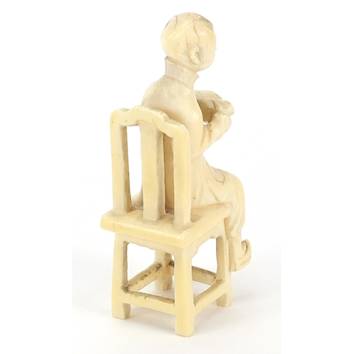 410 - Chinese carved ivory okimono of a boy sitting on a chair, 7cm high