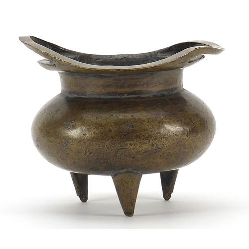 49 - Chinese patinated bronze tripod incense burner with twin handles, character marks to the base, 12cm ... 