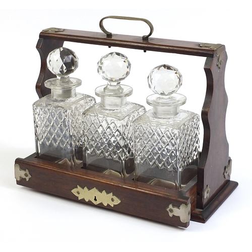 17 - Oak three bottle tantalus with three glass decanters, 35.5cm wide