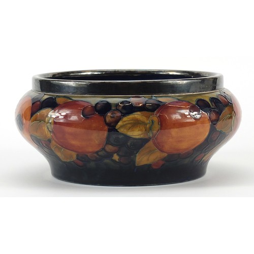 12 - William Moorcroft pottery bowl with silver plated rim hand painted with flowers, 21cm in diameter