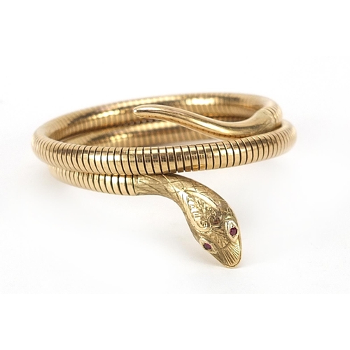 852 - 9ct gold serpent bracelet with ruby eyes and engraved decoration, approximately 36cm in length, 28.7... 