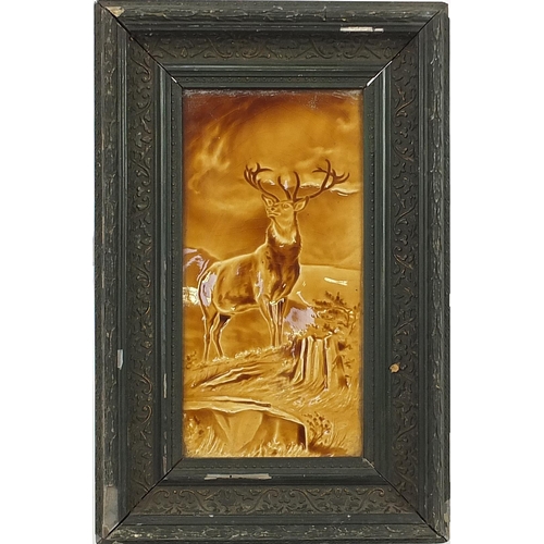 48 - Large Victorian treacle glazed tile hand painted with a stag, framed, the tile 29cm x 14.5cm excludi... 