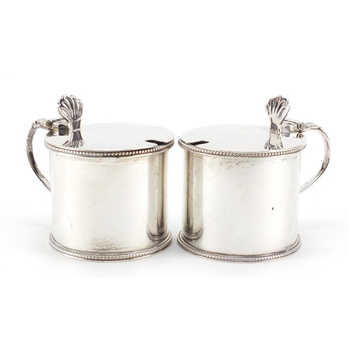58 - Sydney Bellamy Harman, pair of George V silver mustards with hinged lids and blue glass liners, Lond... 