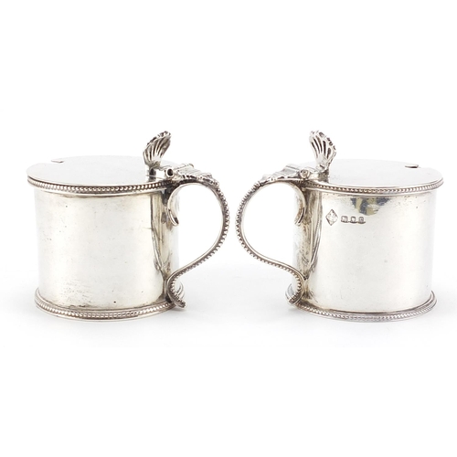 58 - Sydney Bellamy Harman, pair of George V silver mustards with hinged lids and blue glass liners, Lond... 