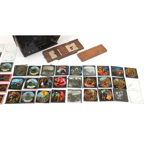 56 - Vintage magic lantern slides with a collection of glass slides, some coloured, the lantern 40cm in l... 