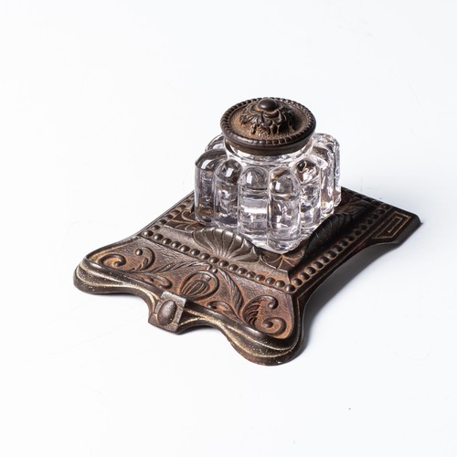 67 - AN ENGLISH GLASS AND CAST IRON INKWELL, CIRCA 1908