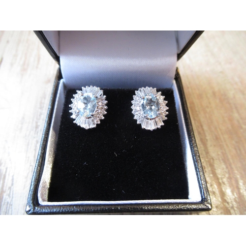 841 - Pair of 18ct white gold aquamarine and diamond earrings of halo design