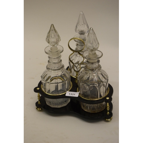 1331 - 19th Century brass mounted black lacquered decanter stand with three various cut glass decanters
