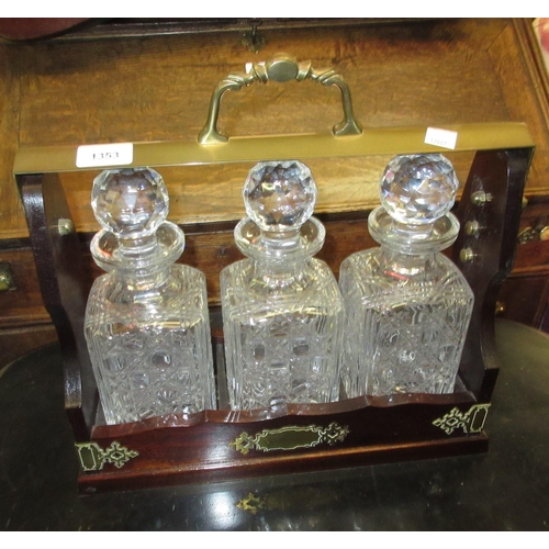 1353 - Reproduction mahogany and brass mounted three bottle tantalus with cut glass decanters