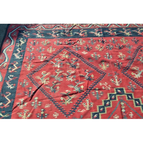 22 - Large Kelim carpet with a five medallion and all-over floral stylised design on a red ground with bo... 