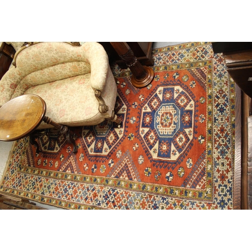 28 - 20th Century Turkish carpet of Kazak design with a triple hooked medallion pattern on a terracotta g... 