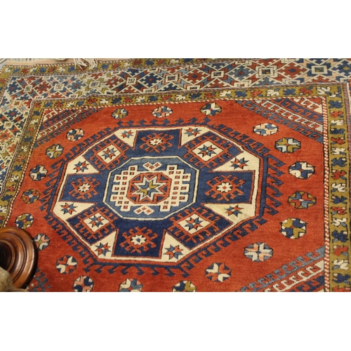28 - 20th Century Turkish carpet of Kazak design with a triple hooked medallion pattern on a terracotta g... 