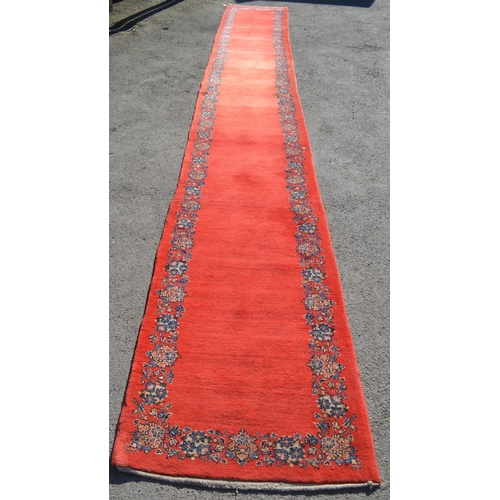 37 - Unusual mid 20th Century central Persian runner, the plain red field with a repeating floral border,... 
