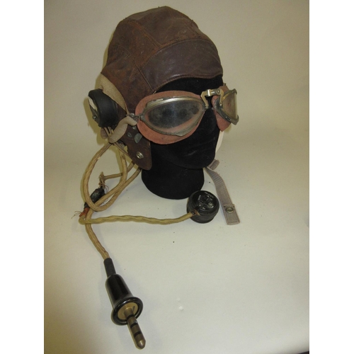104 - Early leather flying helmet with in-built headphones and microphone, together with a pair of aviator... 