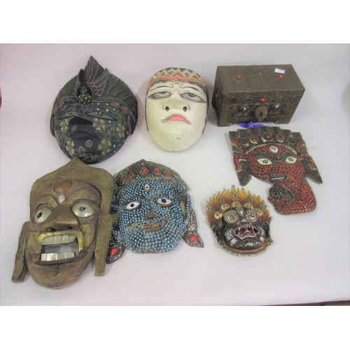 128 - Group of six various oriental carved and wooden wall masks, together with a small brass covered cask... 