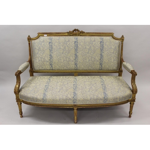 1561 - 19th Century French carved giltwood salon sofa, the shaped back with torch and quiver surmount, the ... 