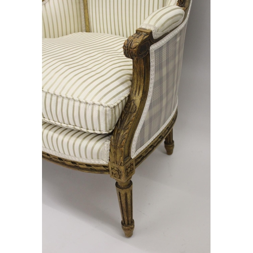 1570 - Pair of 19th Century French carved giltwood wing arm salon chairs upholstered in a striped cream fab... 