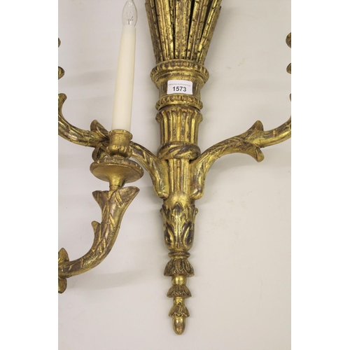 1573 - Pair of 19th Century carved and gilded twin light wall sconces, each with a bow surmount above a qui... 