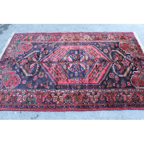 7 - Zanjan rug with a medallion and all-over stylised design on a dark ground with borders, 2.06m x 1.4m