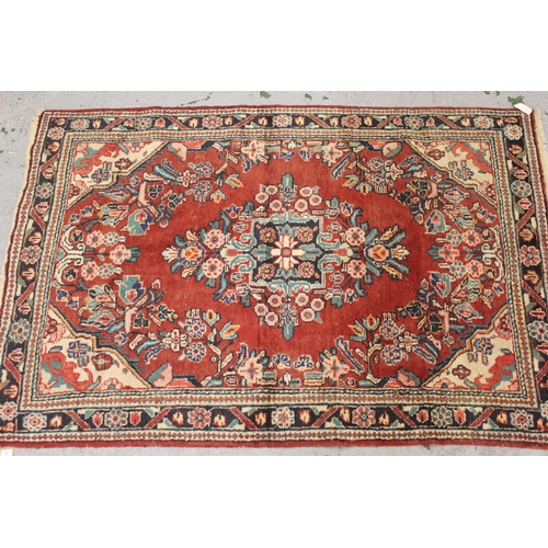 12 - Sarouk rug with a medallion and floral design, on rose ground with borders, 6ft 8ins x 4ft 6ins appr... 