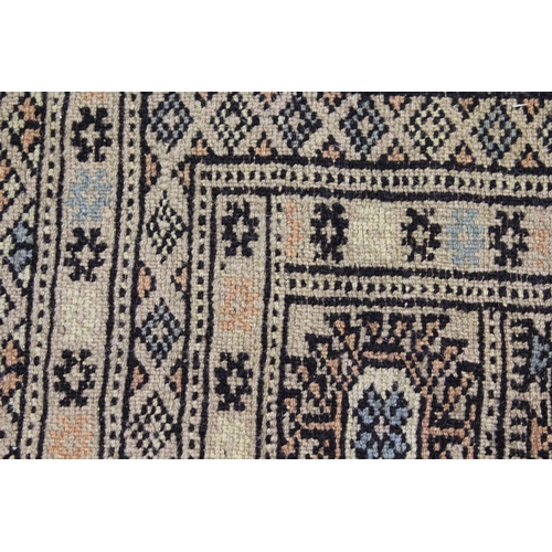 22 - Pakistan Bokhara carpet with six rows of gols on a beige ground with borders, 10ft x 7ft 4ins approx... 