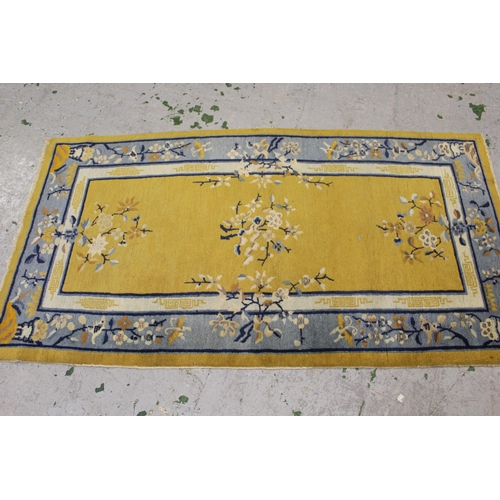 23 - Small Chinese rug with floral design on yellow ground, 5ft 8ins x 3ft 2ins approximately together wi... 