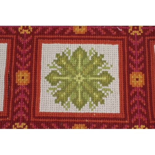 24 - Flatweave woollen rug with an all-over panel design in shades of red, green and cream, 10ft 6ins x 5... 