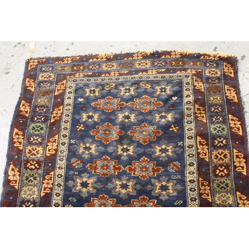 35 - Small Belouch rug with an all over stylised flower head design on a blue ground with borders, 4ft 10... 