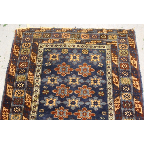 35 - Small Belouch rug with an all over stylised flower head design on a blue ground with borders, 4ft 10... 