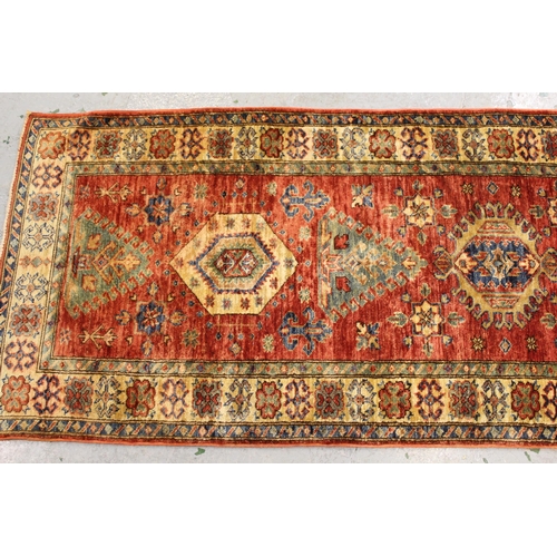 38 - Modern Afghan Ziegler type runner with a repeating medallion and stylised floral design on a brick r... 