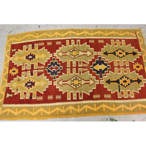46 - Kelim rug with a repeating medallion design on a red ground with borders, 8ft x 4ft10ins approximate... 