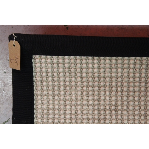 6 - Large modern flat woven woollen carpet with a stitched black fabric border, 6m x 2.4m approximately